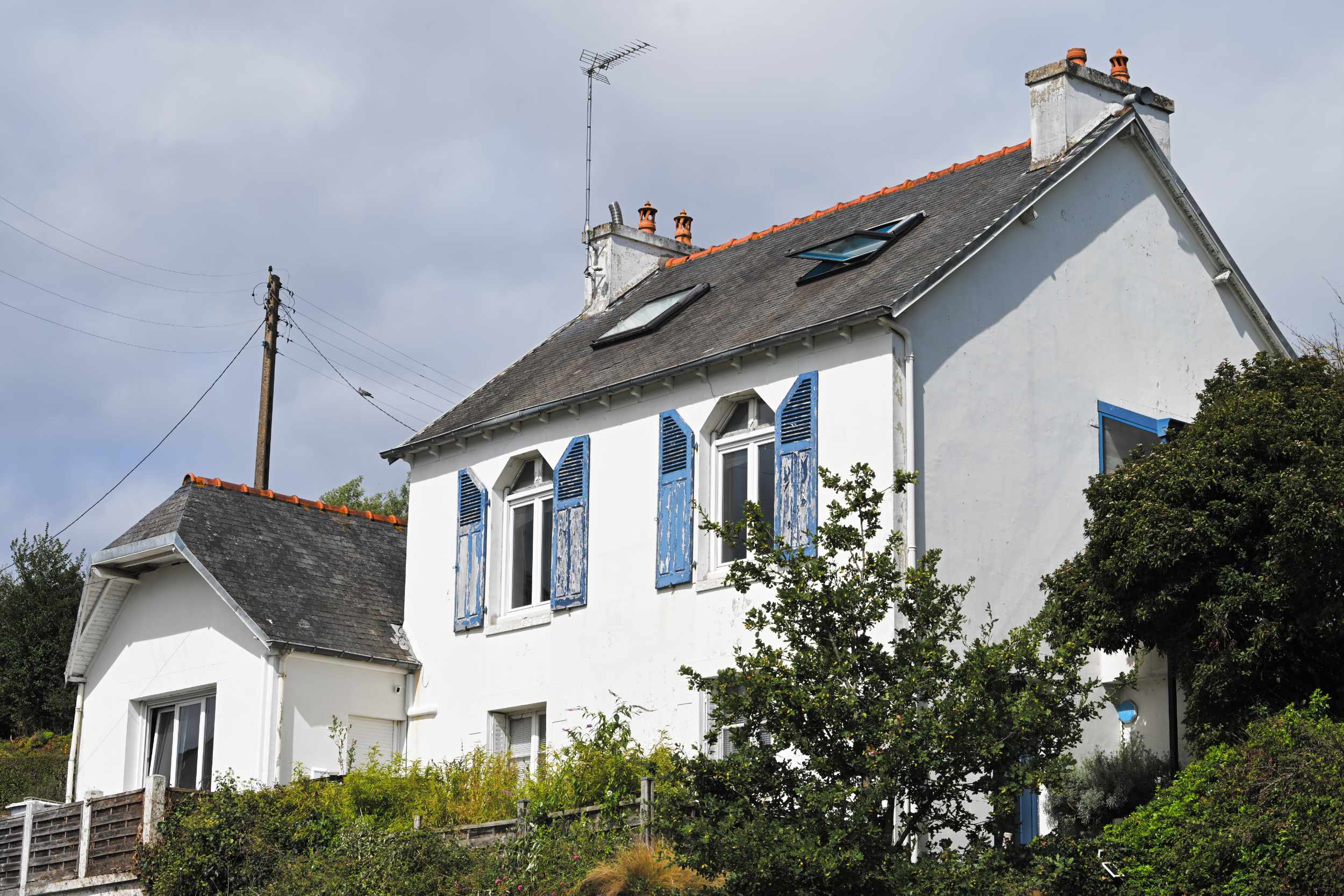 La maison à la façade blanche et aux volets bleus, côté jardin